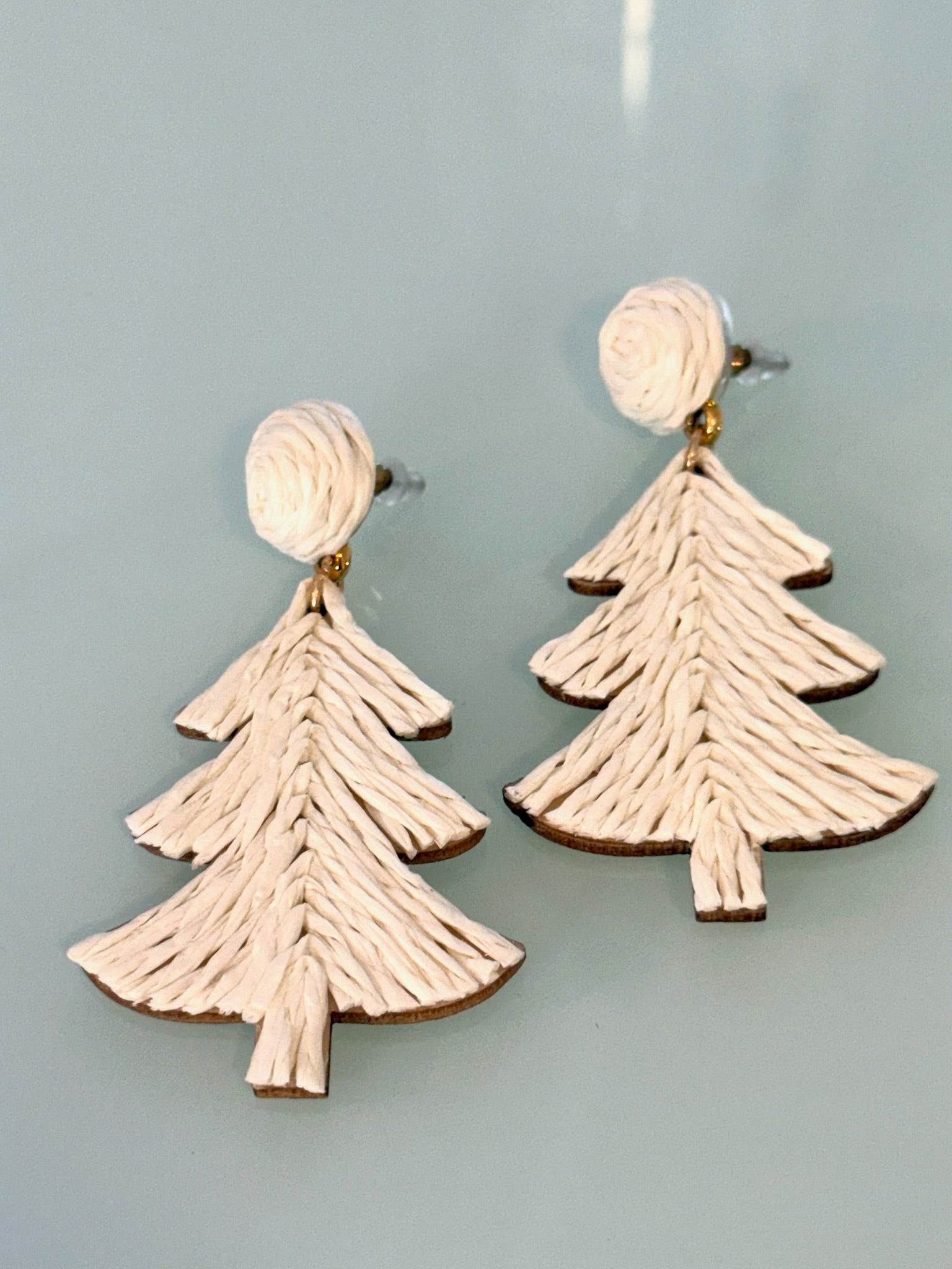 Tree-shaped earrings on a light blue background