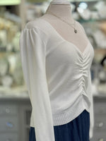 White sweater on a mannequin with a blurred background