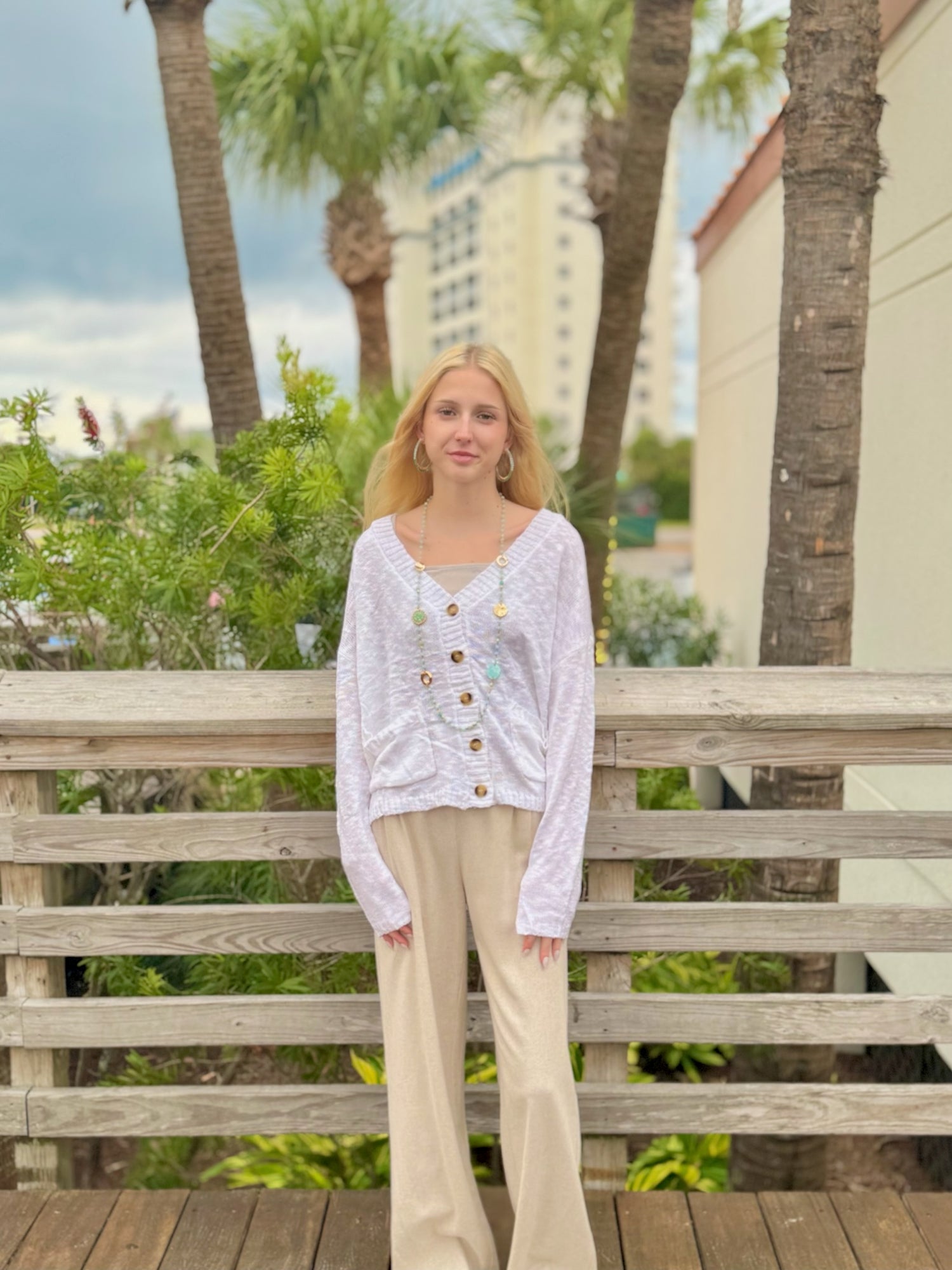 Women wearing a White button front cardigan with pockets, styled casually outdoors. 