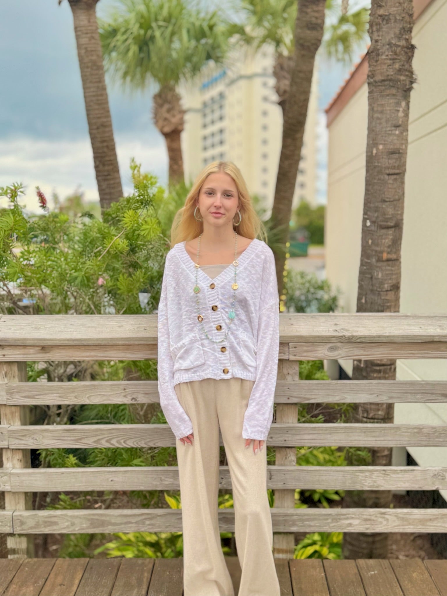 Women wearing a White button front cardigan with pockets, styled casually outdoors. 