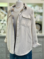 Mannequin wearing a light-colored corduroy shirt with a blurred background