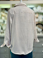 Beige corduroy shirt on a mannequin with a blurred store background