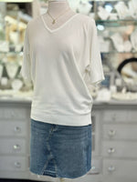 Mannequin wearing a white sweater and blue denim skirt in a store setting