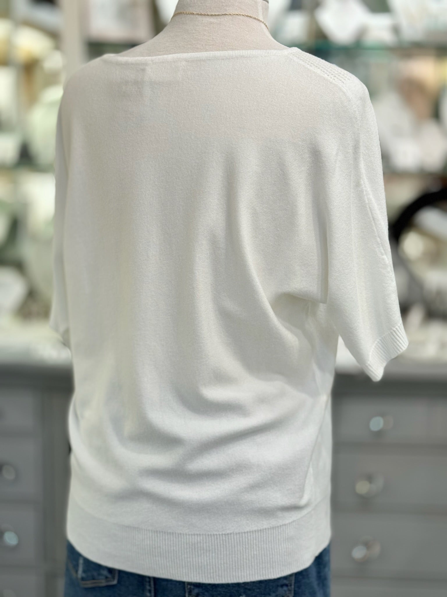 White sweater on a mannequin with a blurred background