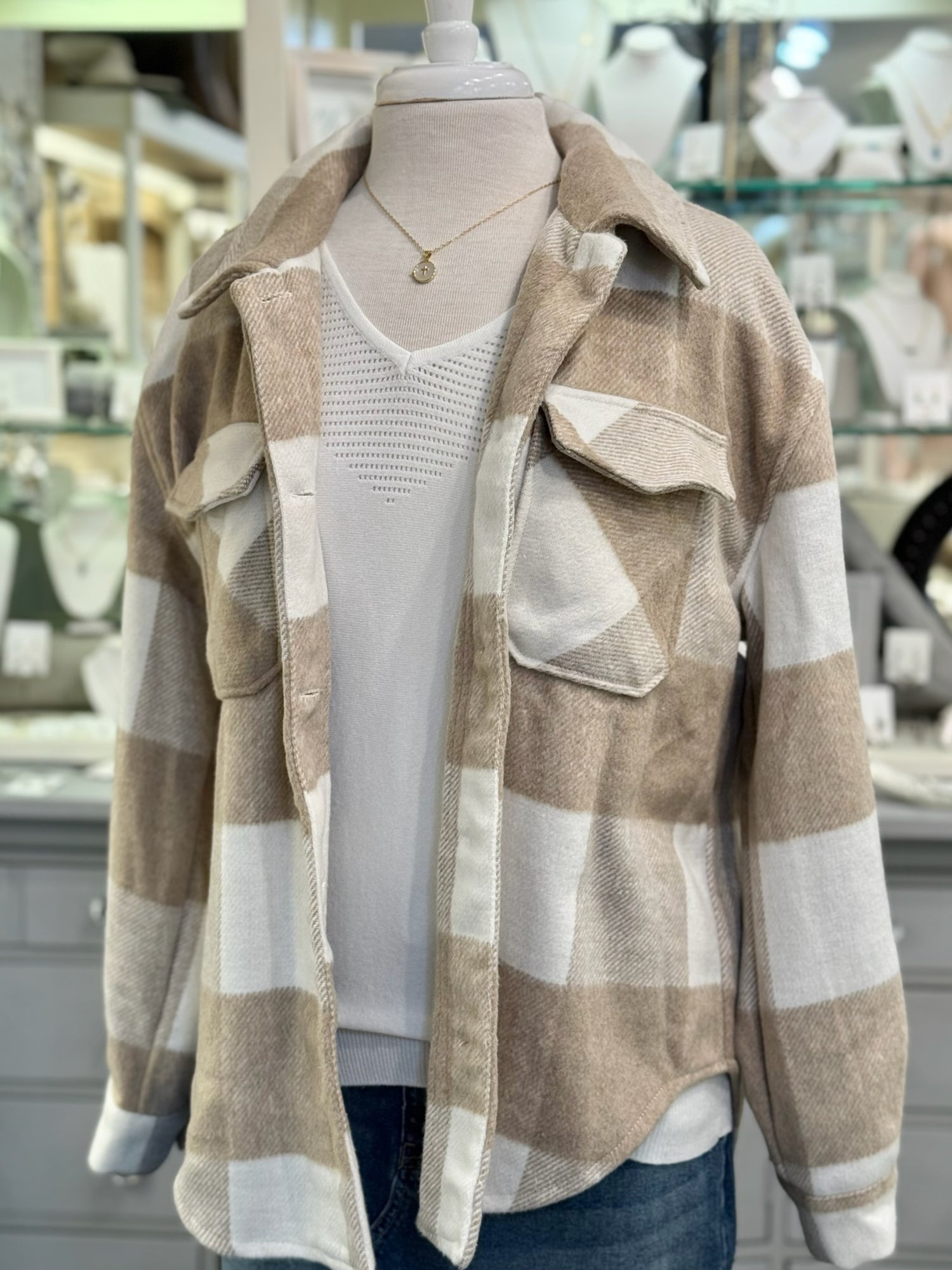 Plaid shirt on a mannequin with a blurred store interior background