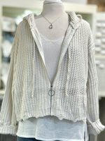 Knitted cardigan with a zipper on a mannequin against a blurred indoor background
