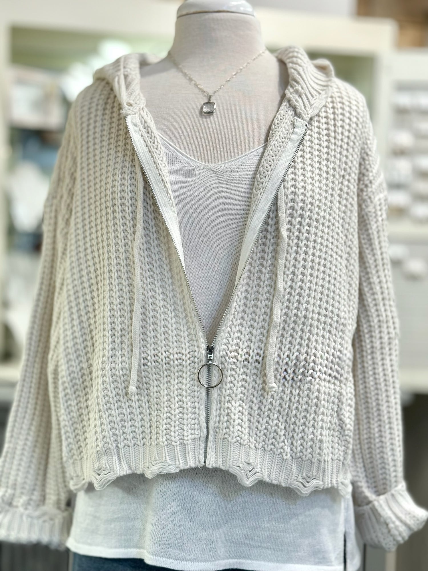 Knitted cardigan with a zipper on a mannequin against a blurred indoor background