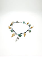 Beaded anklet with hanging seashells, green gemstones, and a clear quartz charm