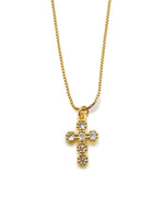 Gold cross necklace with clear stones on a white background
