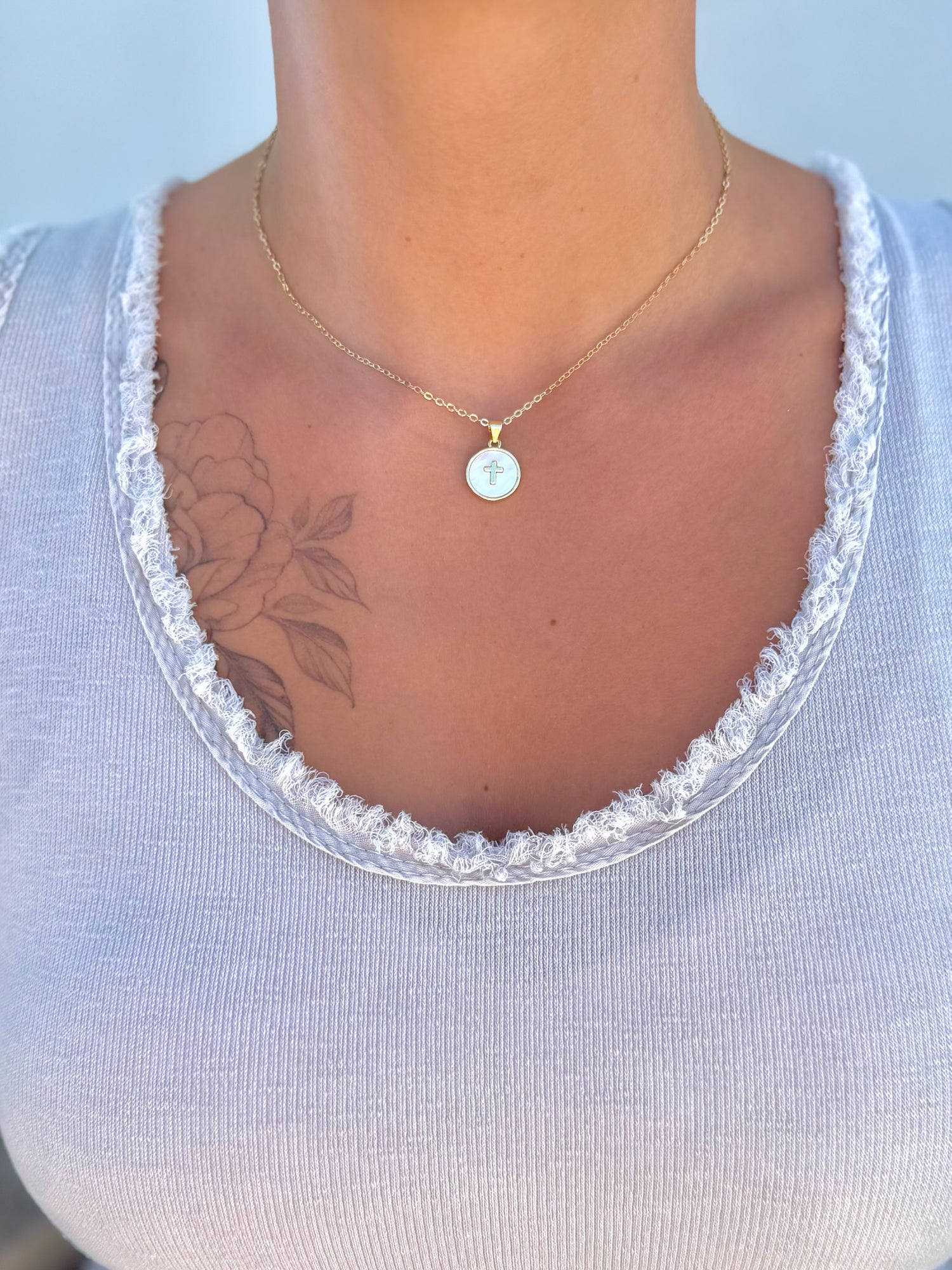 Gold filled mother of pearl cross pendant necklace being worn.