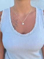 Gold necklace with a butterfly pendant being worn