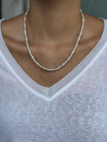 Necklace worn by a person wearing a white shirt