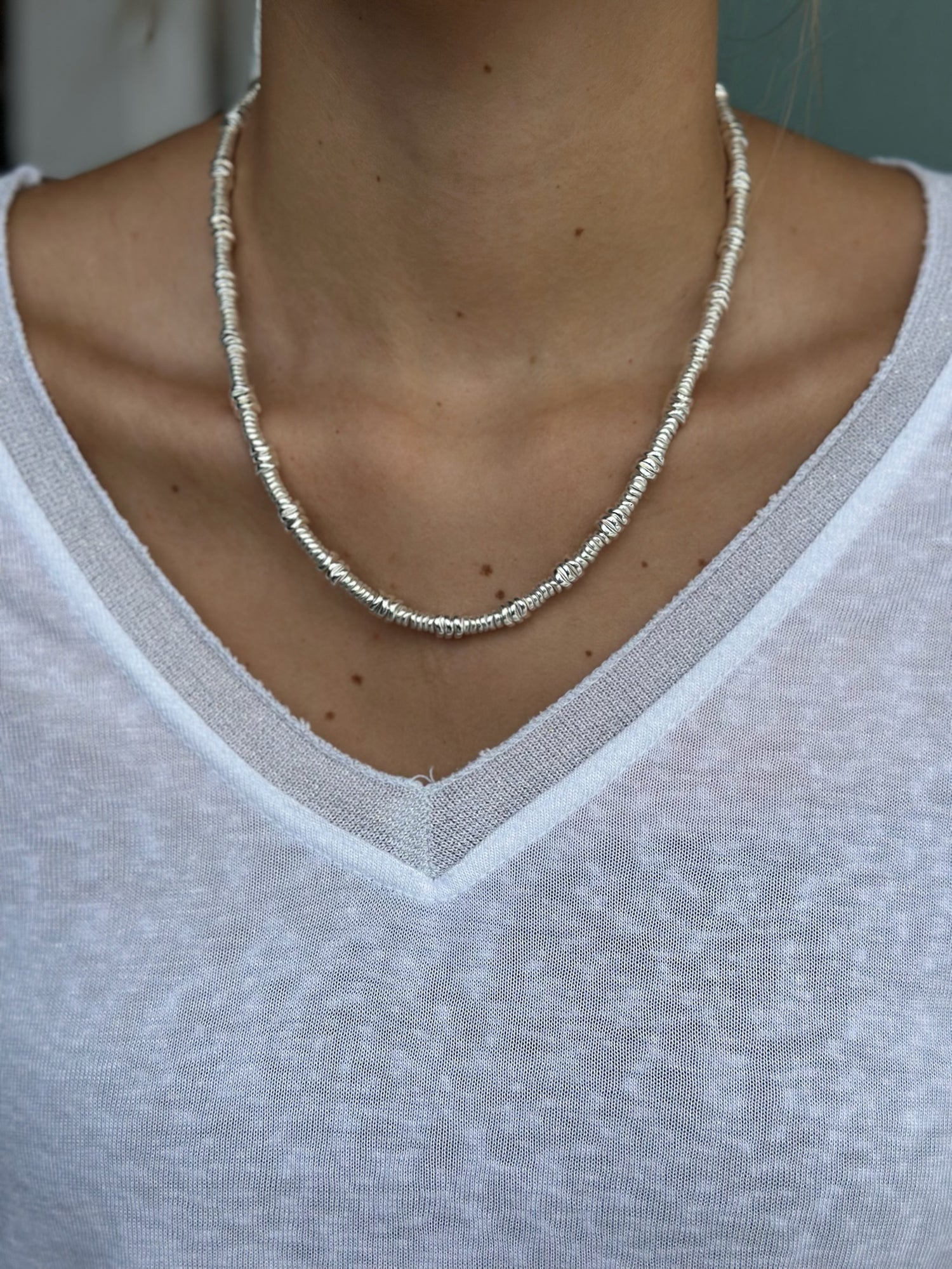 Necklace worn by a person wearing a white shirt