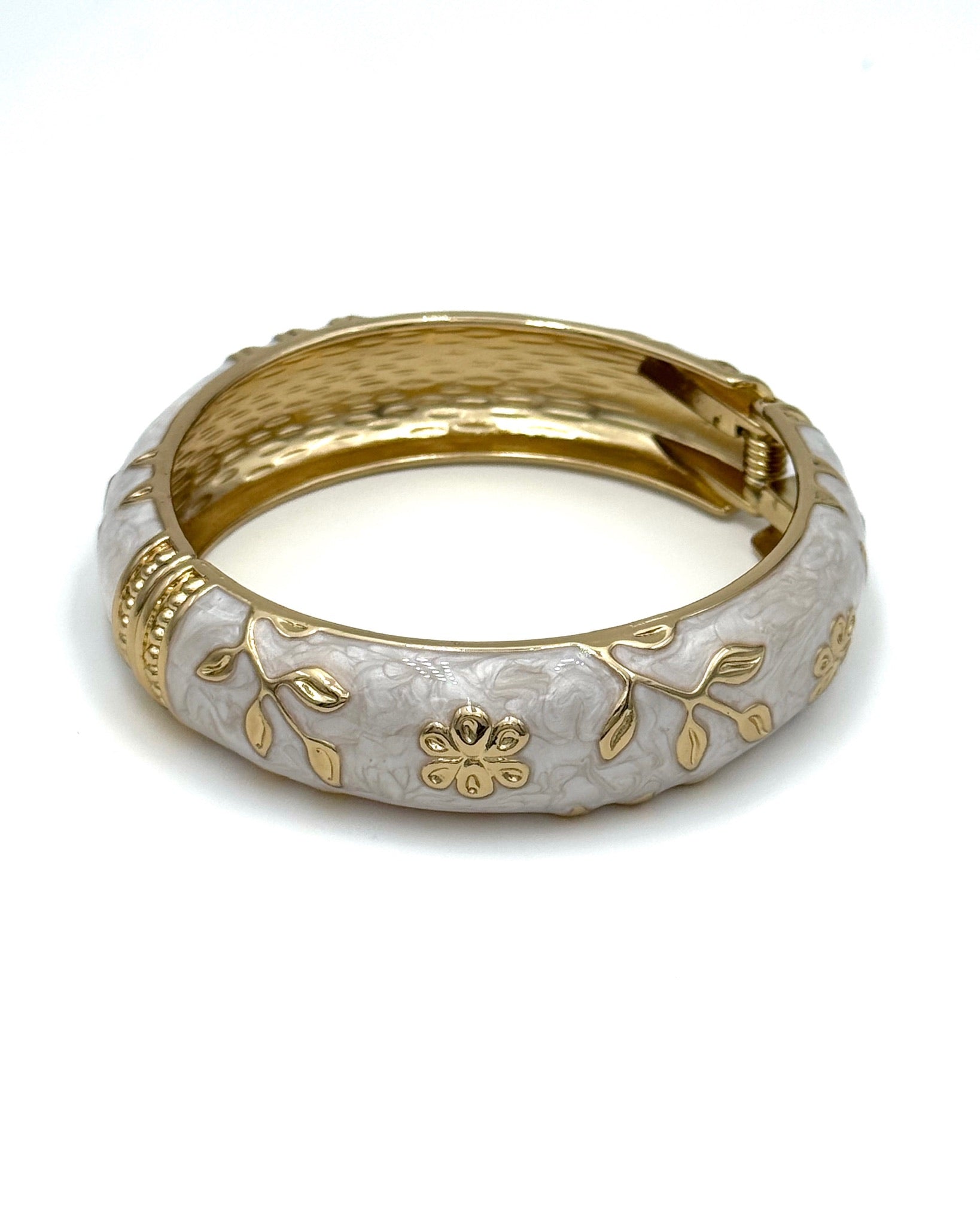 Wide enamel bangle with gold floral detailing and hinge clasp"
