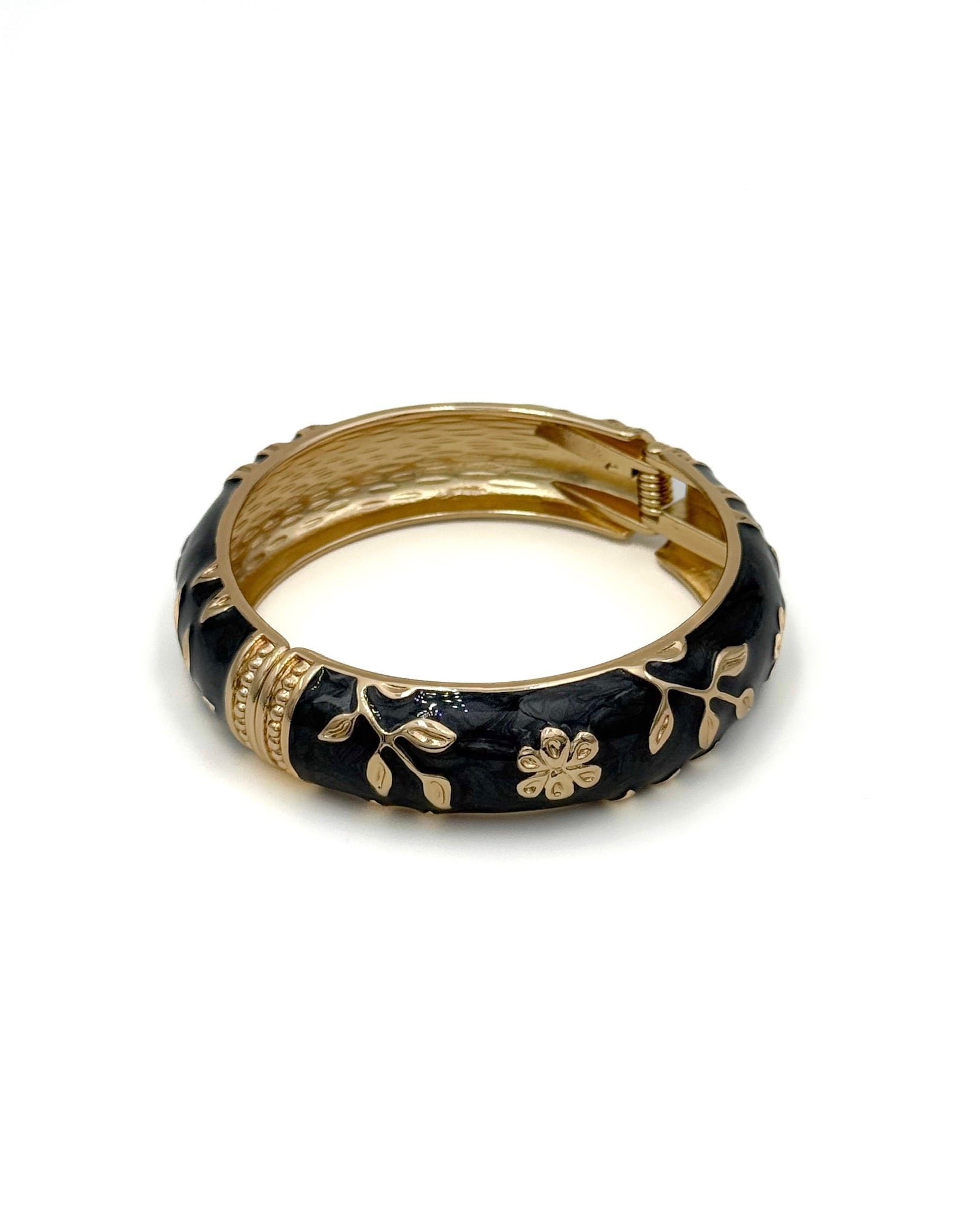 Wide enamel bangle with gold floral detailing and hinge clasp"