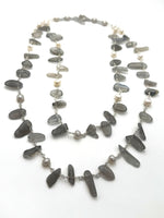 grey stone and pearl double layered necklace on a white background.