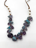 Blue crystal necklace with pearls against a white background