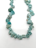 Necklace made of blue-green gemstones on a white background