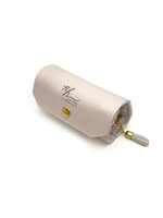 Closed pink Nina Halls jewelry roll-up case with gold hardware and tassel zipper.