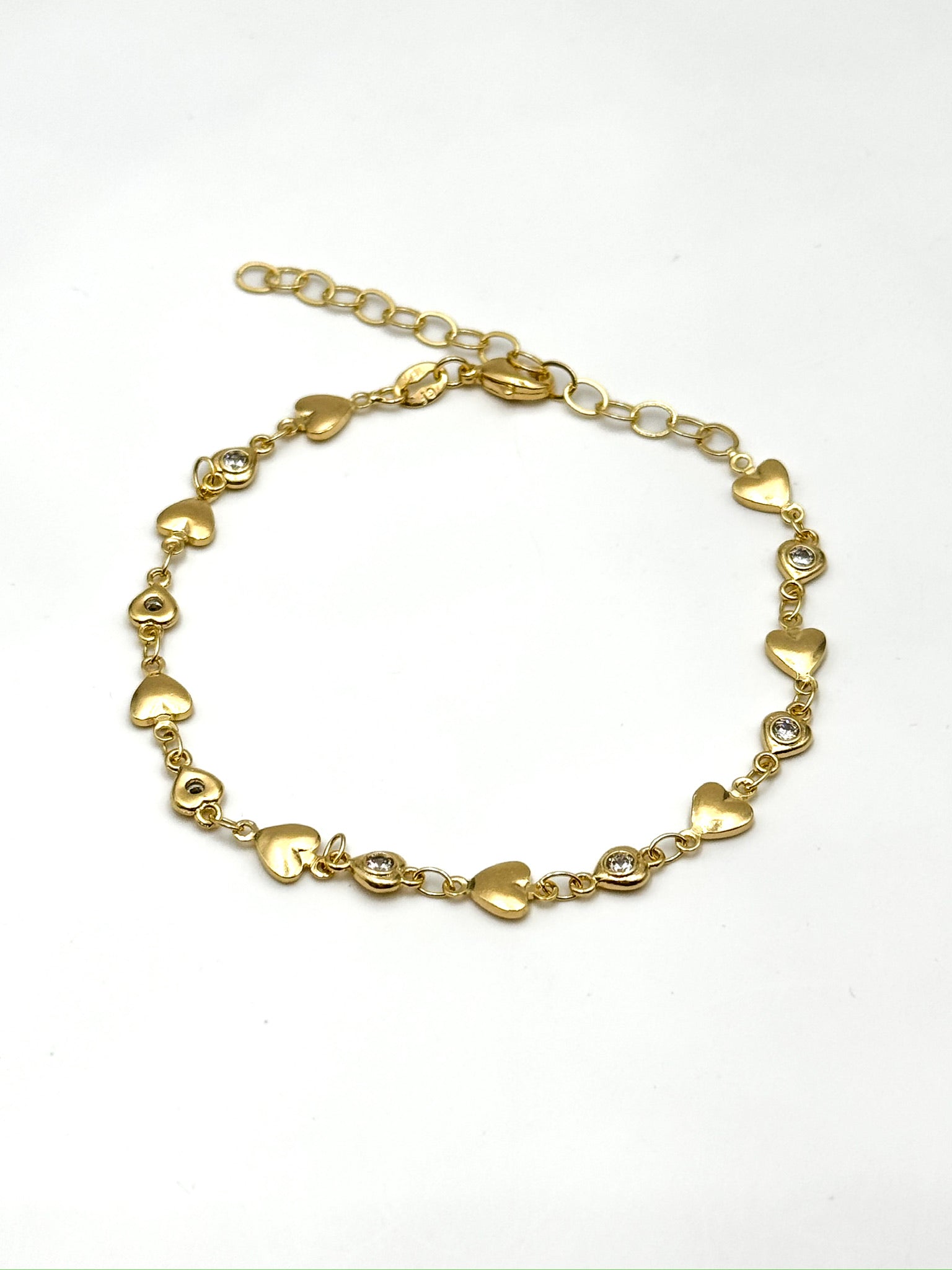 Gold bracelet with heart-shaped links on a white background
