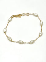 Elise dainty gold-tone chain bracelet with spaced oval pearls and extender clasp on a white background