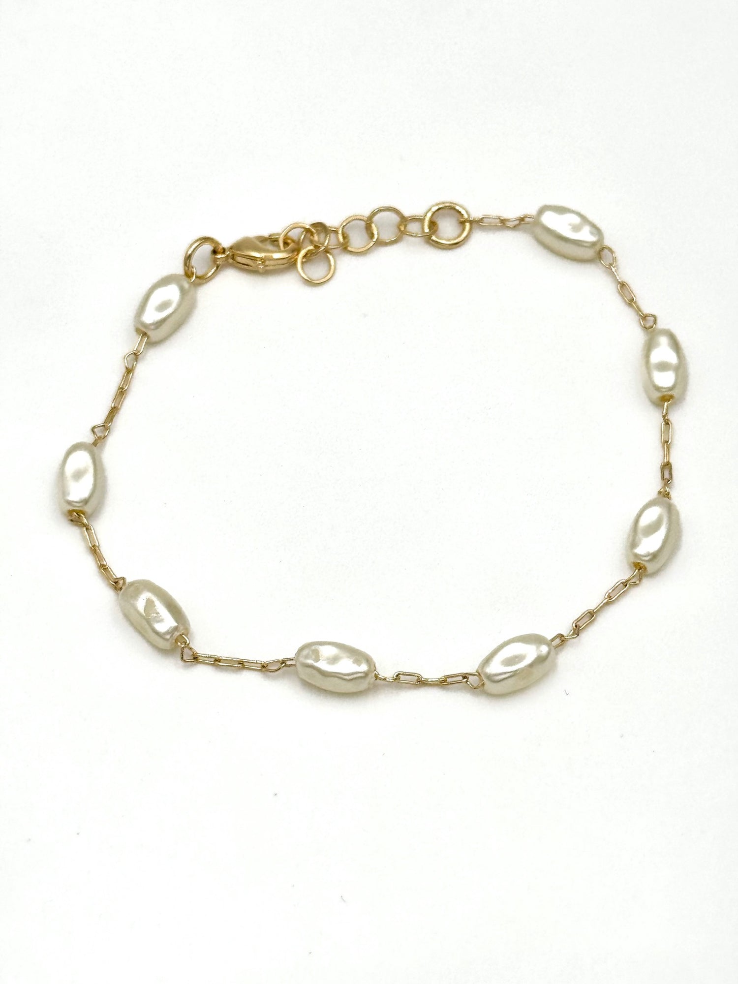 Elise dainty gold-tone chain bracelet with spaced oval pearls and extender clasp on a white background