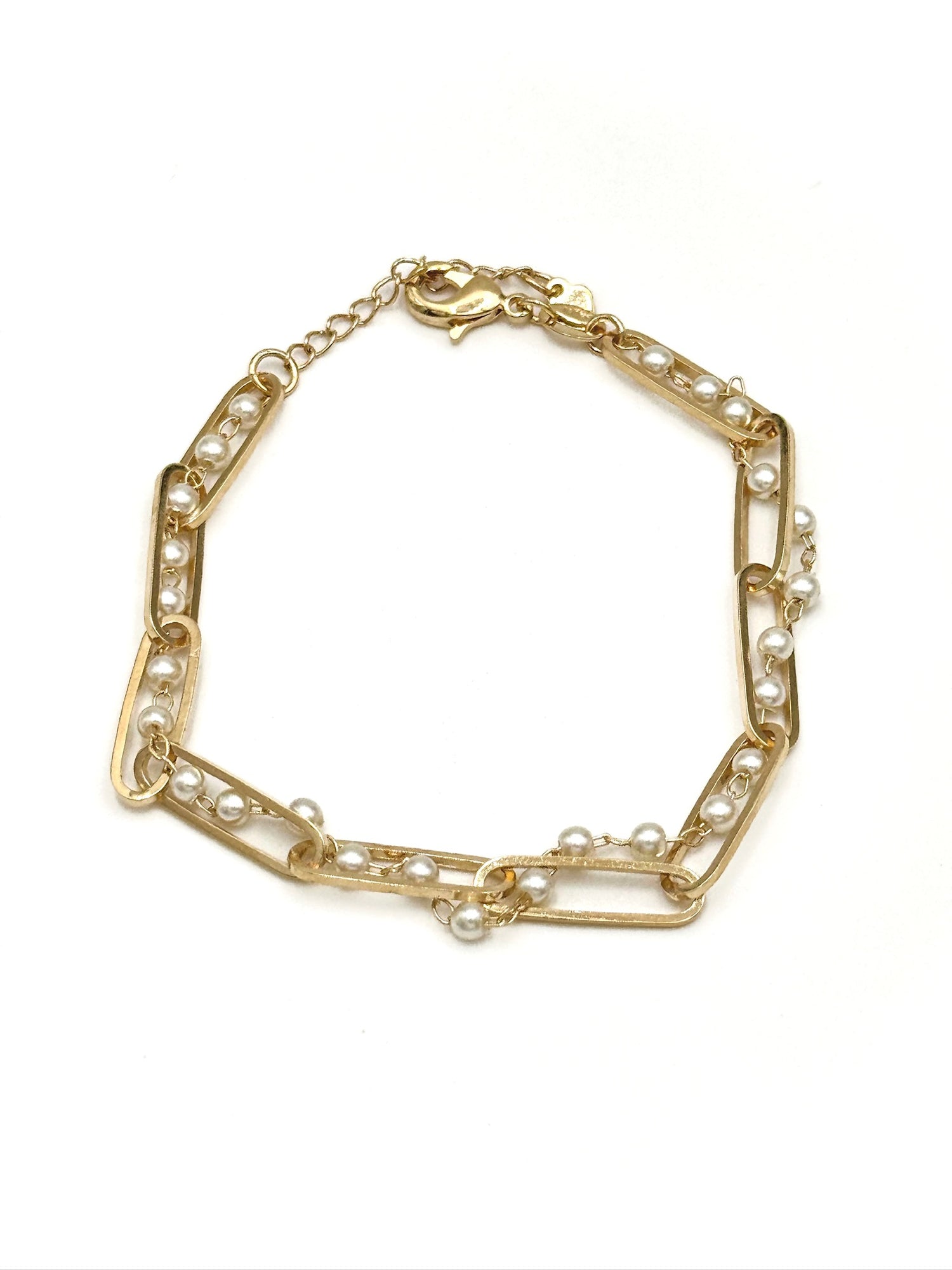 Gold bracelet with pearl accents on a white background