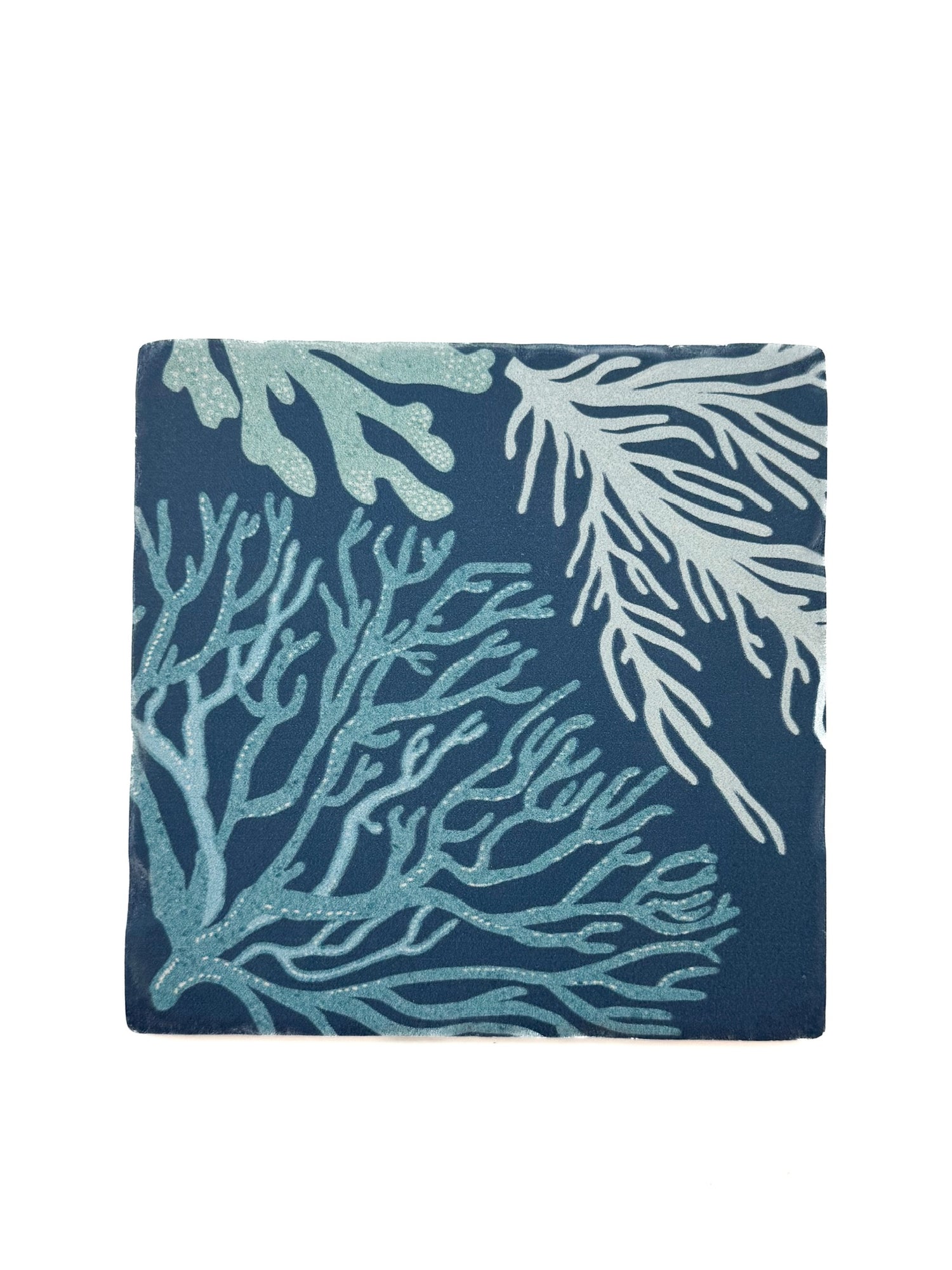 Square ceramic coaster featuring a navy blue background with seafoam and white coral branch design.