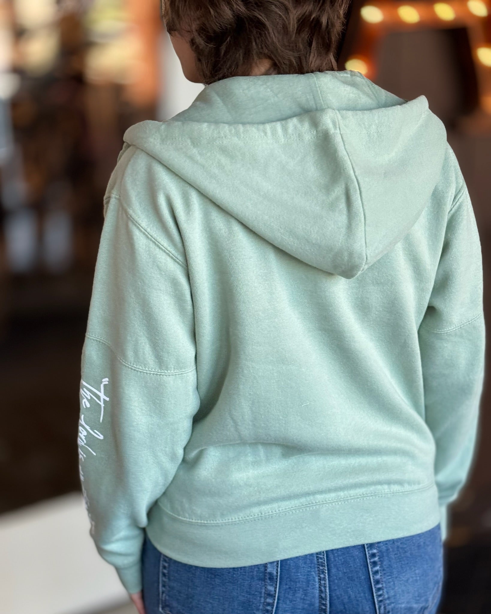 Back view of the sage green lord is my strength hoodie