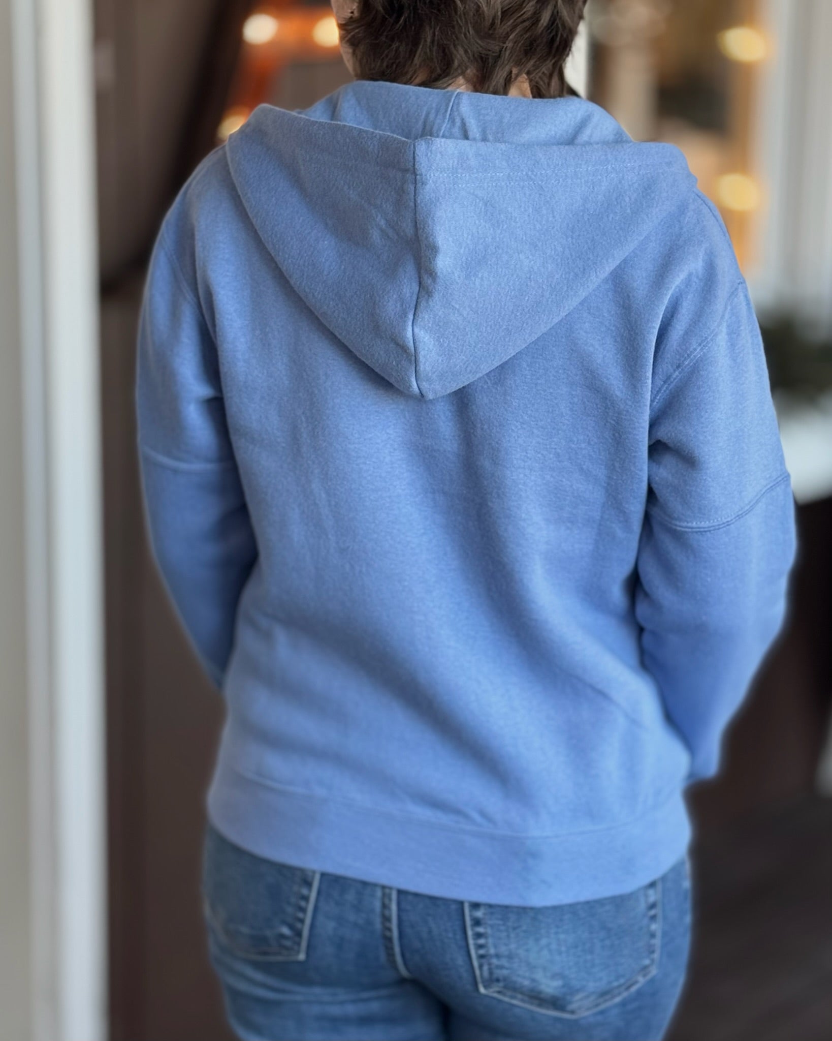 Woman with a blue hoodie on showing the back side fit.