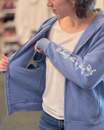 Woman holding sunglasses and showing interior pocket