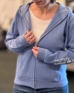 Woman showing the features of the zip up hoodie.