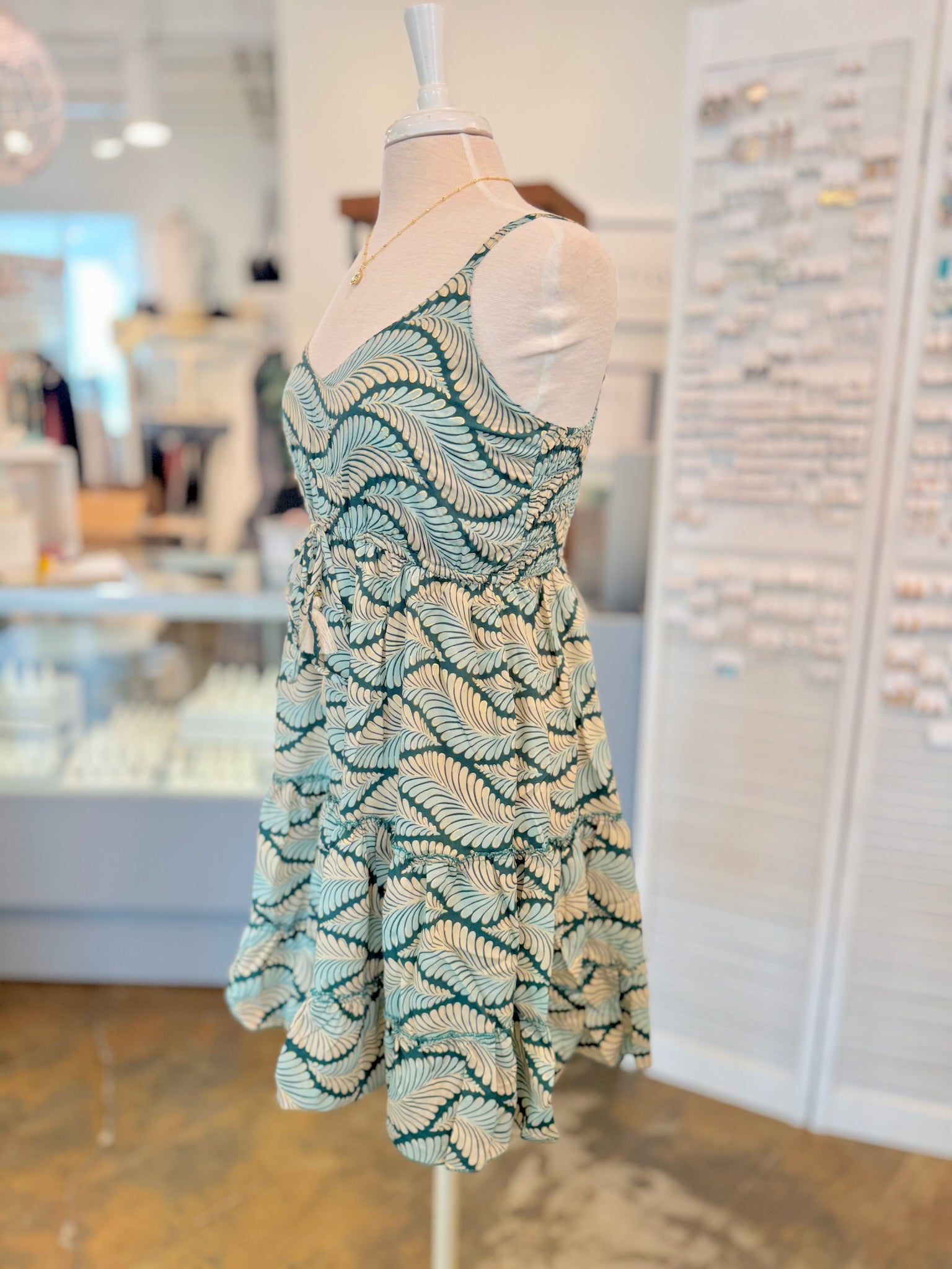 Side view of the Dress showing its slowly tiered skirt and lightweight basic with green leaf print