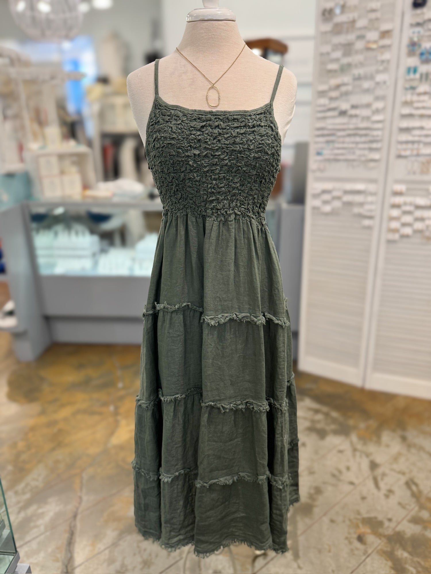 Green dress on a mannequin in a store setting
