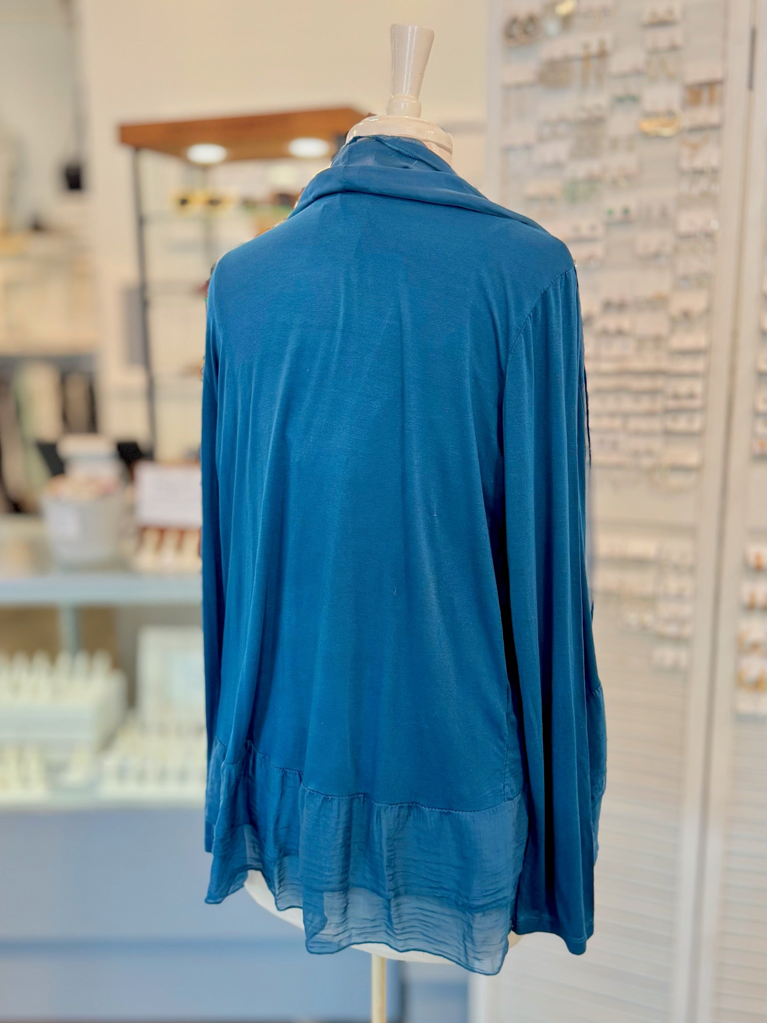 Blue cardigan on a mannequin in a store setting