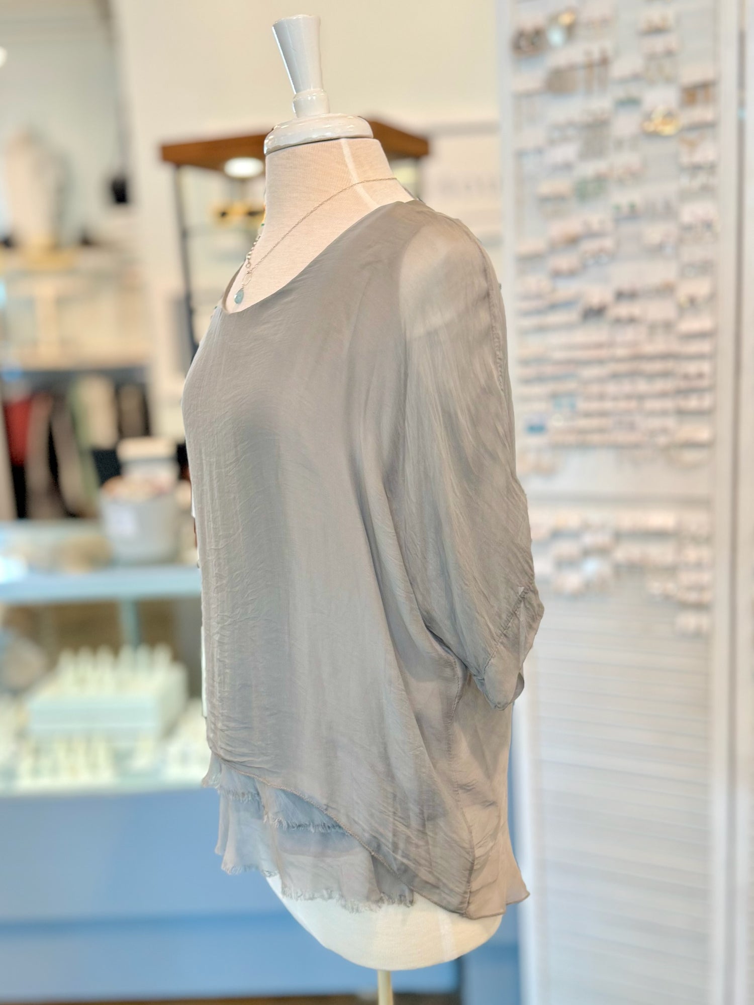 Gray sweater on a mannequin in a store setting