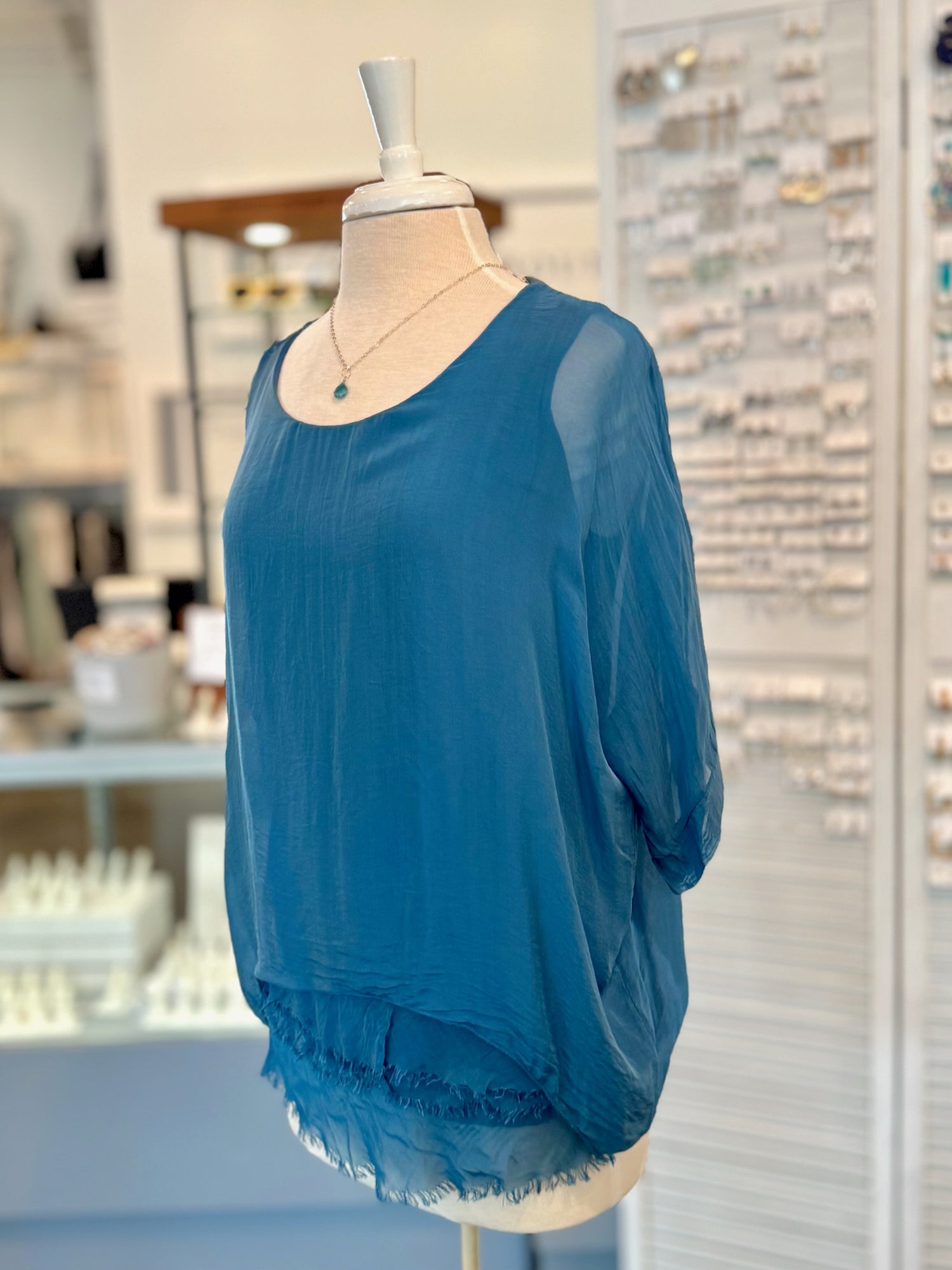 Blue blouse on a mannequin in a store setting
