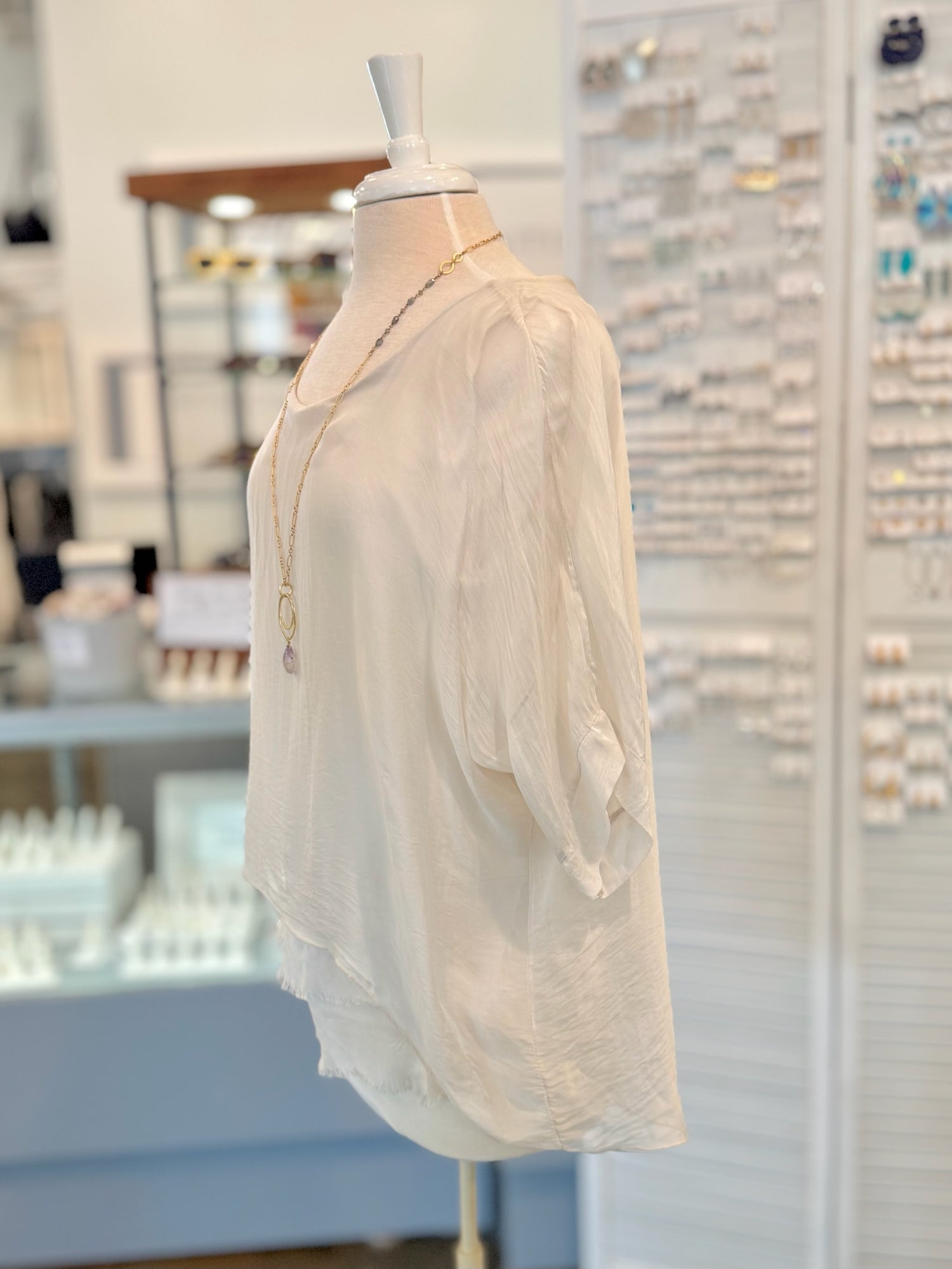 Beige blouse on a mannequin in a store setting