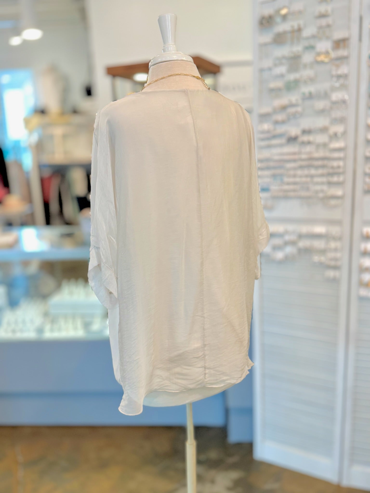 Beige shirt on a mannequin in a store setting