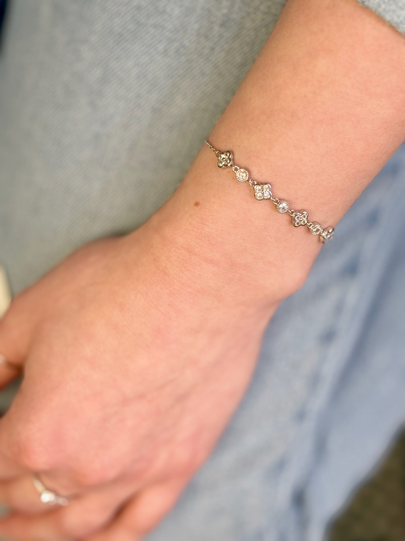 Silver bracelet on a wrist with a neutral background