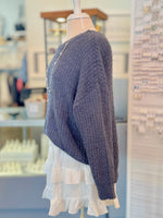 Blue knitted sweater on a mannequin with a blurred store background