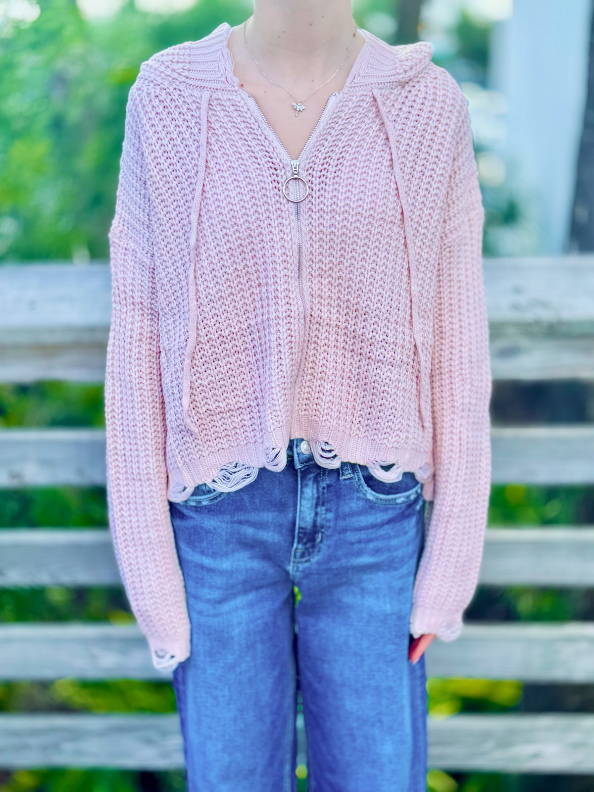 Kennedy Hoodie in blush with an open knit design, hood, ring zipper and distressed trim styled with denim at Ardor Boutique.