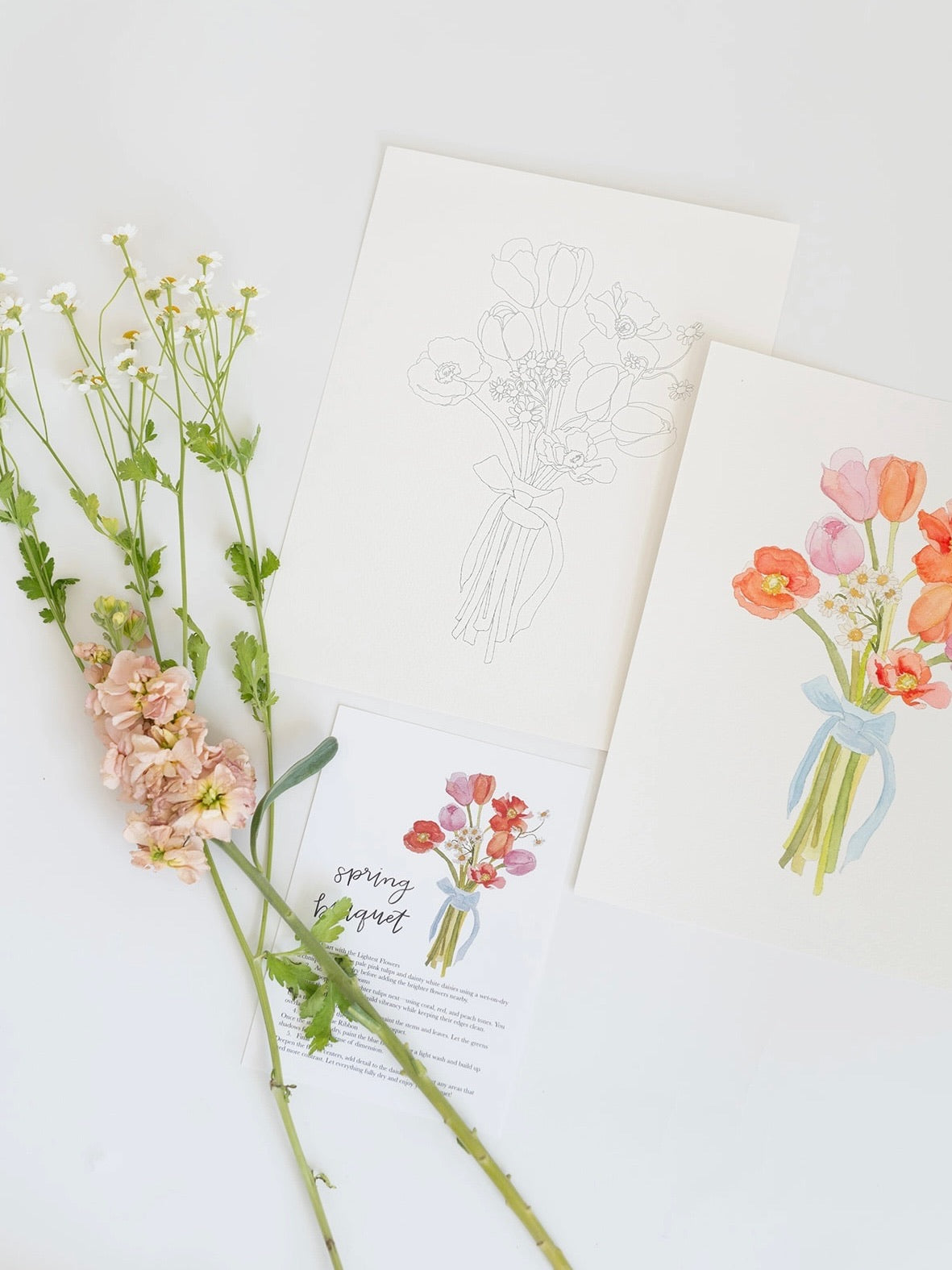 Floral arrangement with greeting cards on a white surface