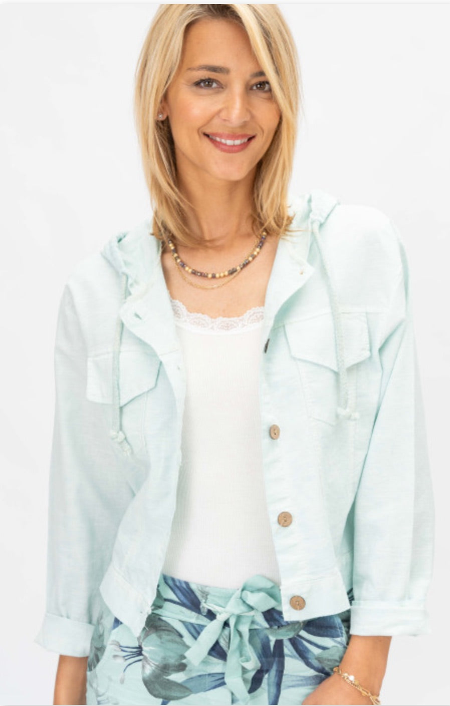 Seafoam lightweight hooded jacket with wooden buttons layered over white lace trim cami