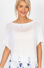 Vanda Italian white open knit sweater with scalloped hem and twist cut-out details styled over navy and white printed pants