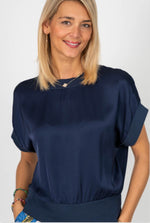 Woman wearing a navy blue blouse against a white background