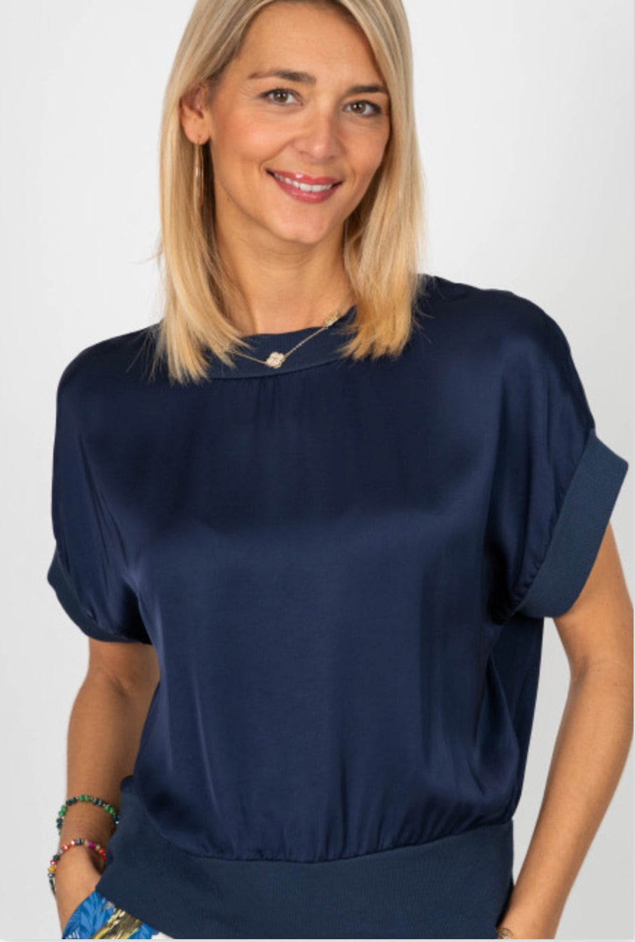 Woman wearing a navy blue blouse against a white background