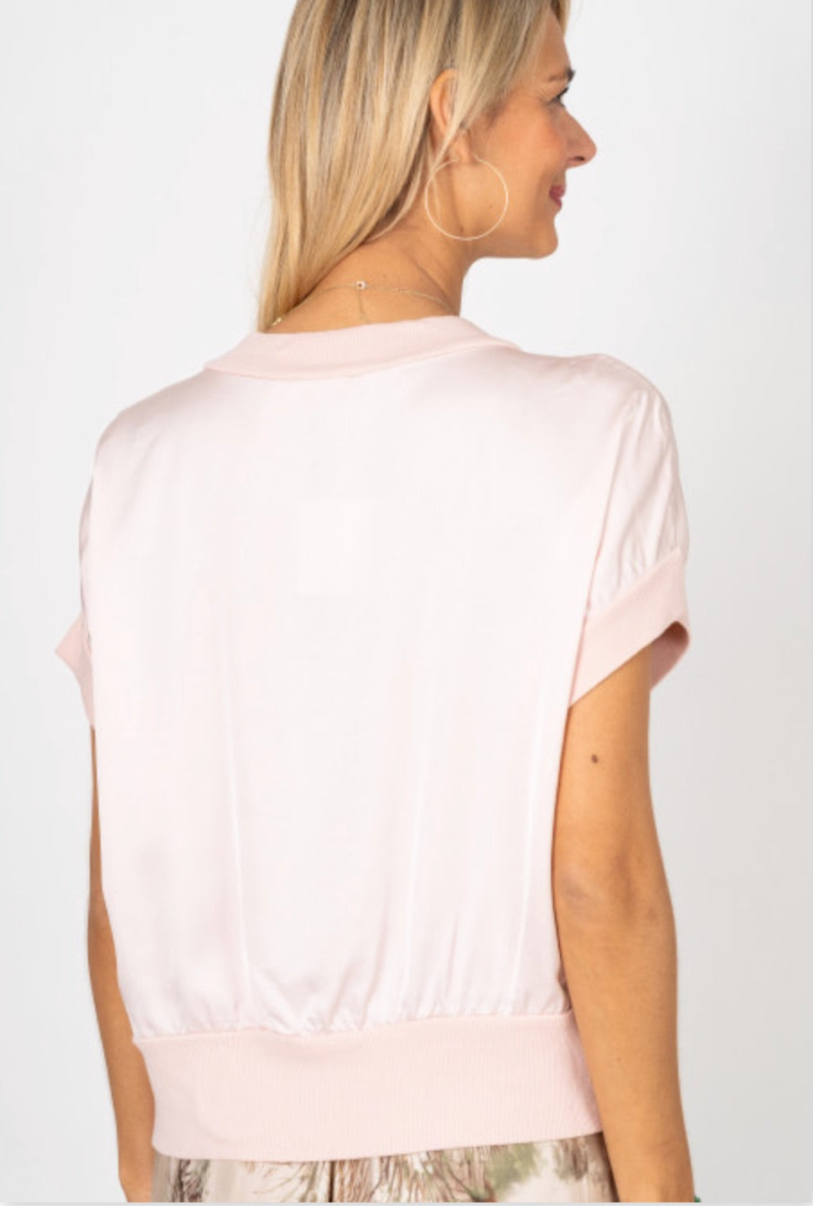 Woman wearing a light pink blouse against a white background