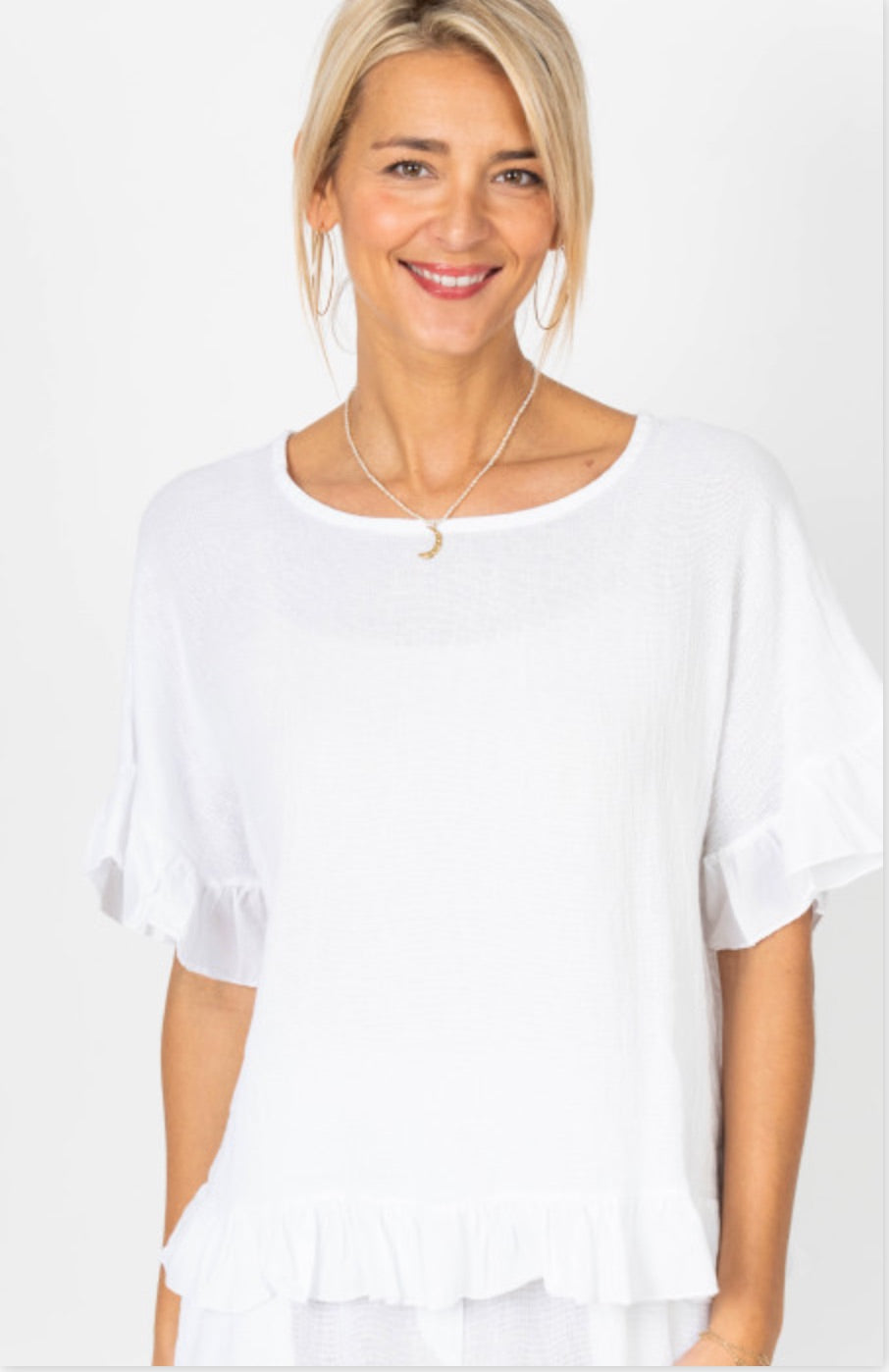 Woman wearing Jillian Italian linen top in white with ruffle sleeves and ruffle hem detail
