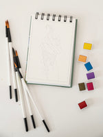 Set of watercolor brushes and color swatches on a white surface